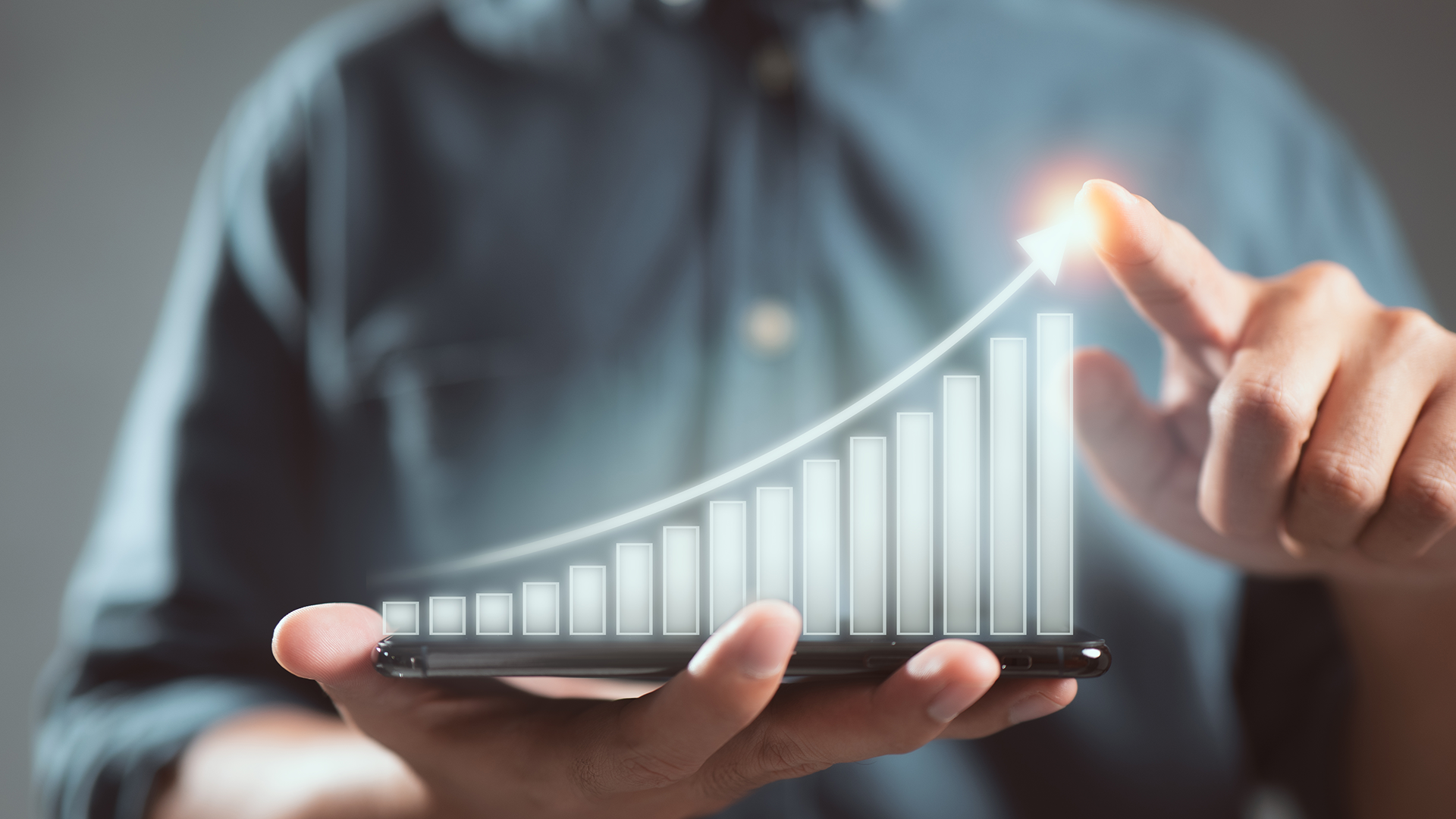 Homem de negócios segura smartphone que projeta gráfico mostrando estatísticas de crescimento