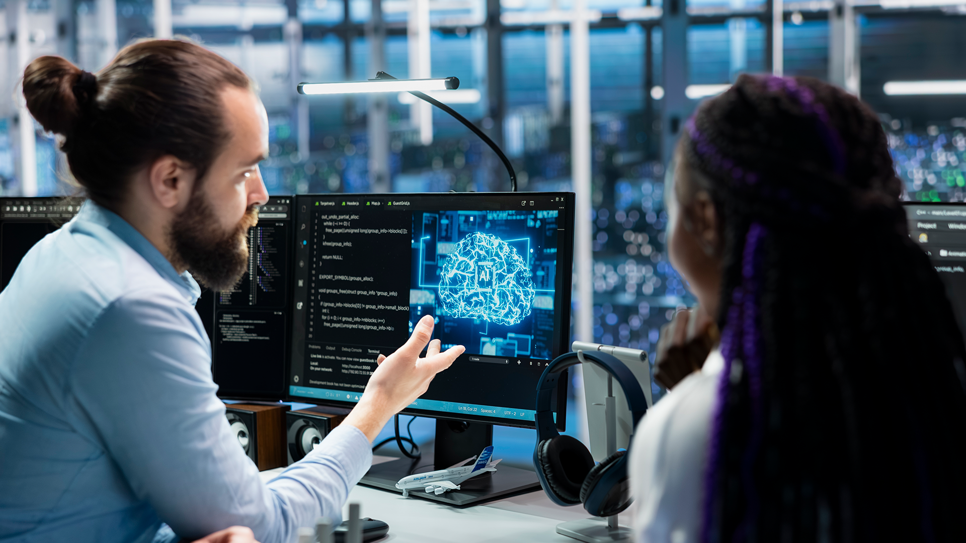 Foto de um data center moderno, com programadores e engenheiros de tecnologia colaborando diante de múltiplos monitores e servidores. A imagem representa o trabalho em equipe no desenvolvimento de inteligência artificial, redes neurais e bancos de dados avançados, destacando a integração entre infraestrutura digital e inovação em IA.